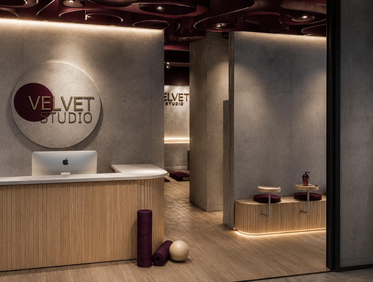 Recepción de Velvet Studio con paredes de concreto, mostrador de madera y detalles púrpuras.